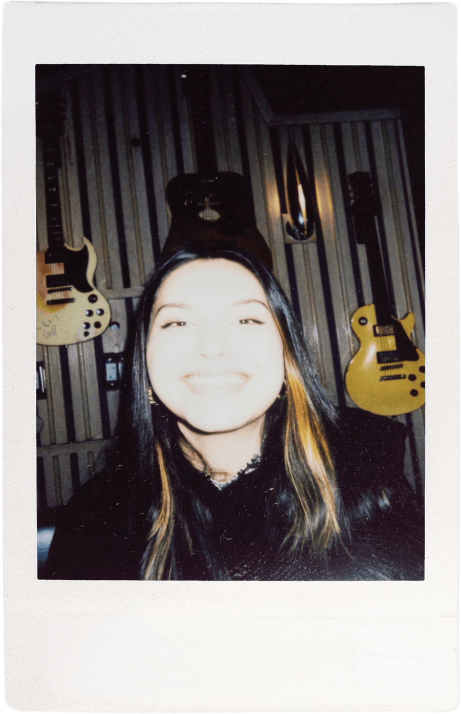Team member with long hair, guitars behind them